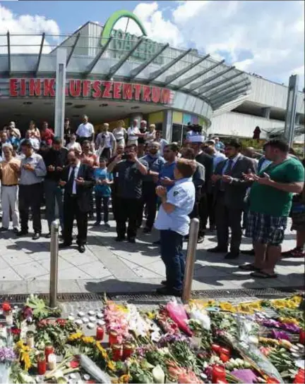  ?? Christof Stache/afp ?? Mensen bidden bij de plaats waar vrijdagavo­nd negen mensen doodgescho­ten werden.