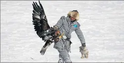  ?? REUTERS ?? A hunter walks with a rabbit, caught by his tame golden eagle, during an annual hunters competitio­n at Almaty hippodrome in Kazakhstan on Friday.