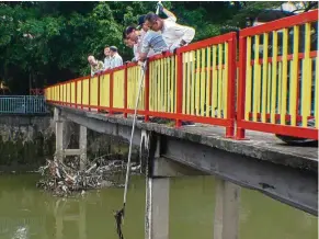  ??  ?? The local community scooping up rubbish from Sungai Batu, part of the ROL project. — GEC