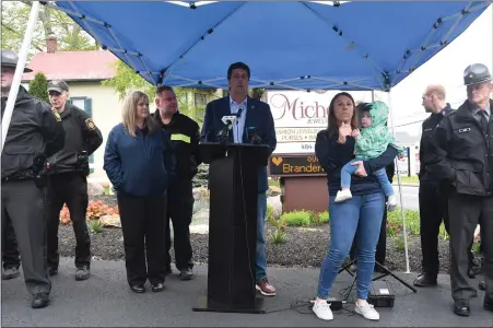  ?? PHOTO CREDIT: TED HODGINS, PERKIOMEN TOWNSHIP FIRE COMPANY ?? State Rep. Joe Ciresi speaks at a road dedication ceremony to honor Trooper Branden T. Sisca, who was killed in the line of duty in 2022. Sisca’s widow, Brittany and daughter, Brynn, are on the right.