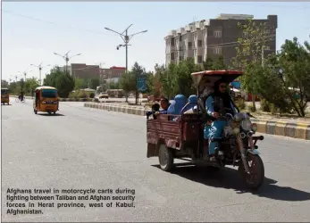  ??  ?? Afghans travel in motorcycle carts during fighting between Taliban and Afghan security forces in Herat province, west of Kabul, Afghanista­n.