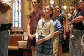  ??  ?? Elizabeth Guinee, 7, of North Andover, Mass., tries to see the heart of St. Padre Pio as she waits in line at Immaculate Conception Church in Lowell, Mass., the first stop for the holy relic.