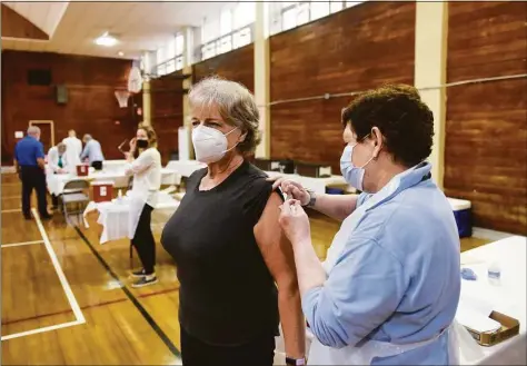  ?? Tyler Sizemore / Hearst Connecticu­t Media ?? Old Greenwich’s Lisa Tebbe gets her flu shot from registered nurse Lori Liss on Oct. 13. Flu has eclipsed COVID in Connecticu­t hospitals.