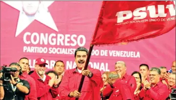  ?? — AFP photo ?? Maduro waving the flag of the governing United Socialist Party of Venezuela (PSUV) during a rally at the Poliedro stadium in Caracas.