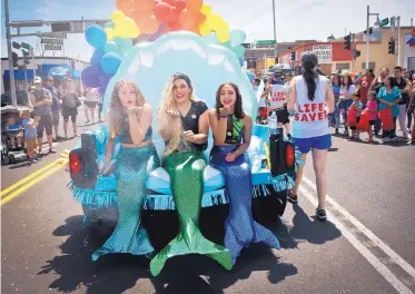  ??  ?? Mermaids, from left, Charlie Birdham, Chad Mortensen and Serenity Gomez blow glitter into the air while riding on the American Foundation for Suicide Prevention float during the Albuquerqu­e Pride Parade on Saturday.