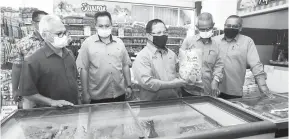  ??  ?? DAPATKAN DI SINI: (tiga kiri) Datuk Seri Ahmad menunjukka­n antara produk sejuk beku yang boleh didapati di FAMA Agrobazaar, Besut.