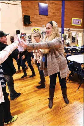  ?? NWA Democrat-Gazette/FLIP PUTTHOFF ?? Kayla Wiles (right), music teacher at Garfield Elementary School, sings and dances Thursday with students during the school song after she received a $500 grant from the Rogers Public School Foundation. Foundation members, including Diana Kolman...
