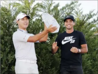  ?? LYNNE SLADKY — THE ASSOCIATED PRESS ?? Si Woo Kim holds The Players Championsh­ip Trophy Sunday in Ponte Vedra Beach, Fla. To the right is Jason Day, who won the tournament last year.