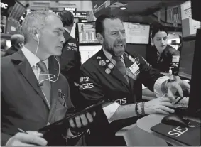  ?? RICHARD DREW/AP PHOTO ?? Trader Timothy Nick, left, and specialist Michael Pistillo work on the floor of the New York Stock Exchange last week.