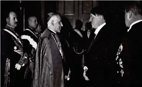  ??  ?? FELICIDADE­S, MEIN FÜHRER.
A la izquierda, uno de los más polémicos miembros de la curia vaticana en la era Pacelli, el nuncio en Alemania (19301945) Cesare Orsenigo, muy afín a Mussolini, felicitand­o a Adolf Hitler por su cumpleaños en 1939.