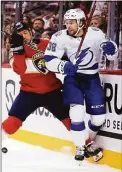  ?? Lynne Sladky / Associated Press ?? Panthers defenseman Brandon Montour, left, and Lightning left wing Brandon Hagel go against the boards during a game in April.