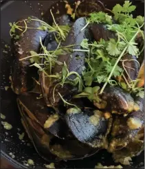  ?? (Arkansas Democrat-Gazette/Eric E. Harrison) ?? Coconut Ginger Mussels, one of the “share” plates at Petit & Keet, are steamed in green curry, fresh ginger and “aromatics.”