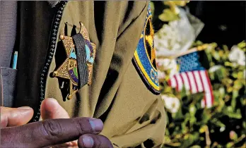  ?? APU GOMES/GETTY-AFP ?? A police officer wears a badge with a mourning strip Friday outside the Borderline Bar and Grill in Thousand Oaks, Calif.