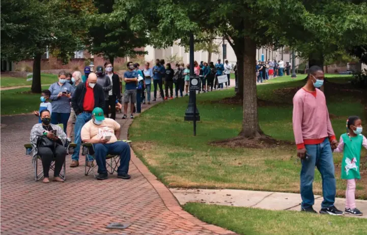  ??  ?? Velgere står og sitter i kø for å få stemme i byen Decatur, i delstaten Georgia i USA.