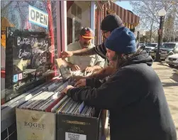  ??  ?? Marvin Phillips of Yuba City, front, looks through piles of records at The Corner To-go and Cilantro’s Beats & Eats event held on Plumas Street on Sunday afternoon.