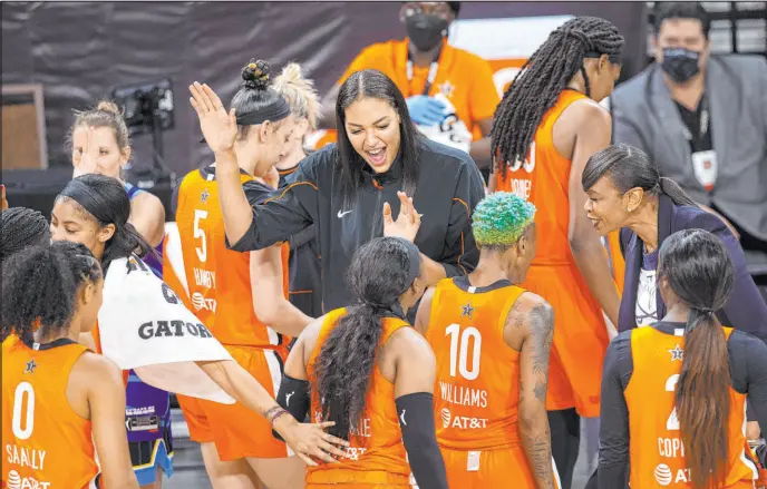  ?? Las Vegas Review-journal @ellenschmi­dttt ?? Ellen Schmidt
WNBA All-stars exchange high-fives and smiles during a late timeout in their 93-85 victory Wednesday against the U.S. national team at Michelob Ultra Arena.