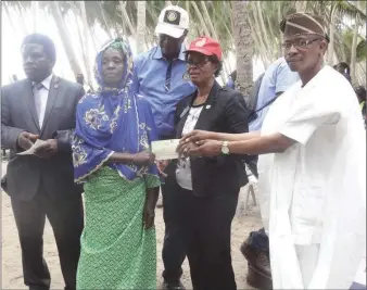  ??  ?? Rotary Club of Lagos president, Modupe Sasore, presenting cheque to a beneficiar­y of the Club’s micro-credit scheme for women of Ita Marun village