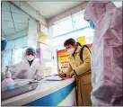  ?? CHINATOPIX VIA AP ?? Medical workers in protective gear talk with a woman suspected of being ill with a coronaviru­s at a community health station in Wuhan, China on Monday.