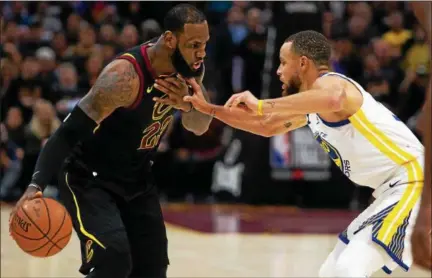  ?? MICHAEL JOHNSON — THE NEWS HERALD ?? LeBron James works against Warriors guard Stephen Curry during Game 3 of the NBA Finals on June 6 at Quicken Loans Arena.