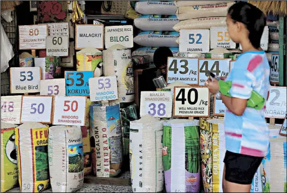  ?? MICHAEL VARCAS ?? Prices of commercial rice are seen at a Kamuning market stall in Quezon City the other day.