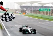  ?? AP PHOTO BY ANDY WONG ?? In this April 9 file photo, Mercedes driver Lewis Hamilton of Britain gets the checkered flag to win the Chinese Formula One Grand Prix at the Shanghai Internatio­nal Circuit in Shanghai, China.