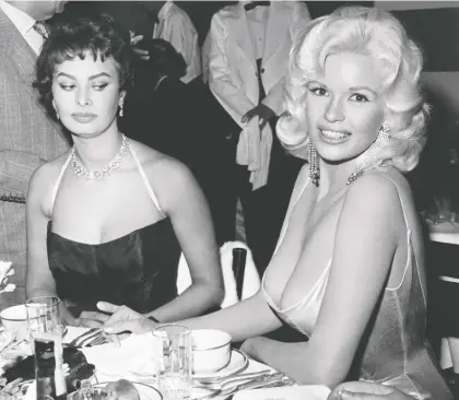  ?? JOE SHERE/MPTVIMAGES.COM ?? What was Sophia Loren, left, really thinking as she sat next to Jayne Mansfield during a glitzy party in 1957? “Look at the picture. Where are my eyes? I'm staring at her nipples because I am afraid they are about to come on to my plate,” Loren admitted in 2014.