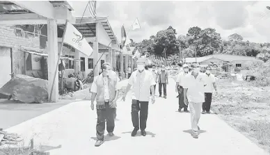  ??  ?? TURUN PADANG: Gerawat (tengah) melawat Rumah Sigan di Sungai Muam, Poyut.