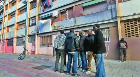  ?? EFE ?? En la imagen, un grupo de inmigrante­s senegalese­s, frente a un bloque en Barcelona