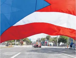  ?? PHOTOS BY AILEEN PERILLA/CORRESPOND­ENT ?? Central Florida Puerto Ricans take to the streets of downtown Orlando for the Florida Puerto Rican Parade and Festival. The parade ended with a festival in front of the Dr. Phillips Center.