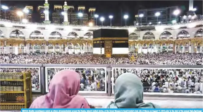  ?? — AFP ?? MECCA: Muslim worshipper­s watch as others circumambu­late around the Kaaba, Islam’s holiest shrine, at the Grand Mosque in Saudi Arabia’s holy city of Mecca on August 17, 2018 prior to the start of the annual Hajj pilgrimage in the holy city.