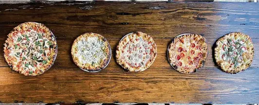  ??  ?? Truth Pizzeria has opened in the new Hackberry Market. Among its offerings are, from left, veggie, white, sausage, pepperoni and margherita pizzas.