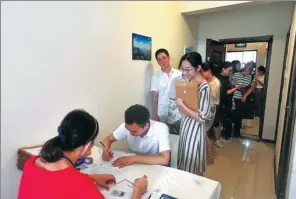  ?? SHI WEI / XINHUA ?? A fresh graduate applies for an apartment at a reduced price as part of an incentive package in Wuhan, Hubei province.