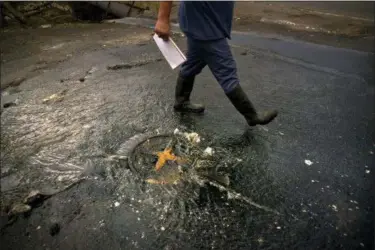  ?? RAMON ESPINOSA — THE ASSOCIATED PRESS ?? A man walks past an overflowin­g storm drain, in Dorado, Puerto Rico. Raw sewage is pouring into the rivers and reservoirs of Puerto Rico in the aftermath of the aftermath of Hurricane Maria. Islanders have been urged to avoid drinking or touching...