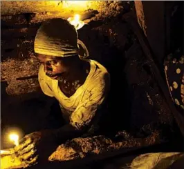  ?? DIEU NALIO CHERY/AP ?? Dieusel Gerlin, a “bayakou,” or waste cleaner, uses candles for illuminati­on before descending into an outhouse pit.