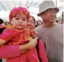  ?? —LEAHAGONOY ?? NOT IN CEBU A couple dress their child in clothes resembling those worn by the Sto. Niño icon during festivitie­s in Pagadian City.