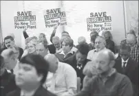  ?? Photo by Ernest A. Brown ?? Protesters hold up signs in a packed hearing room A during a preliminar­y hearing at the Public Utilities Commission headquarte­rs in Warwick Tuesday morning.