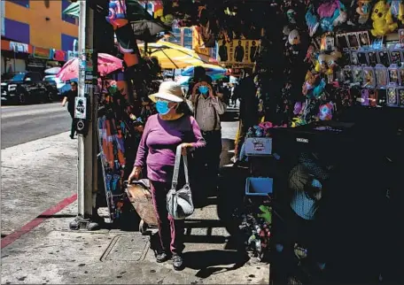  ?? Jason Armond Los Angeles Times ?? PEOPLE shop and work in Santee Alley amid the surge in coronaviru­s cases last week in the heart of Los Angeles’ fashion district.