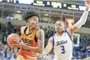  ?? [PHOTO BY IAN MAULE/TULSA WORLD] ?? Oklahoma State Cowboys guard Michael Weathers (23) gathers a rebound in front of Tulsa Golden Hurricane guard Elijah Joiner (3) Wednesday night at the Reynolds Center in Tulsa.