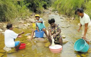  ?? FILE ?? Residents from Freeman’s Hall on one of their weekly washdays at the Quashie River in Trelawny.