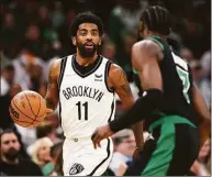  ?? Maddie Meyer / TNS ?? Kyrie Irving (11) of the Brooklyn Nets dribbles downcourt against Jaylen Brown of the Boston Celtics during the first quarter on April 17 in the first round of the Eastern Conference Playoffs in Boston.