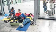  ?? Picture: Getty. ?? Top: chaos at BA check-in desks at Heathrow. Above: yoga mats served as makeshift beds for stranded passengers. The disruption could continue for several days with the airline facing major compensati­on costs.