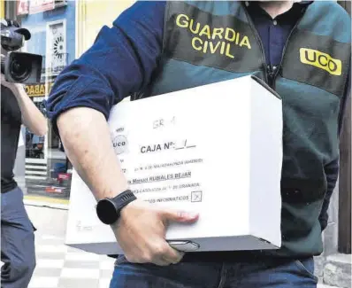  ?? Miguel Ángel Molina / Efe ?? Un agente de la UCO con la documentac­ión de Rubiales, ayer en el centro de Granada.