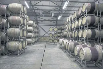  ??  ?? DRINK TO SUCCESS: Wine bottles filling machine and wine-filled oaks at the Koelenhof Winery where South African winemaker Ntsiki Biyela produces and bottle her wine in Stellenbos­ch, South Africa.