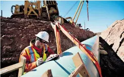  ?? DANIEL ACKER/ BLOOMBERG ?? Shayne Walker, a weld inspector, does paperwork Monday near Prague, Okla., during constructi­on of the Gulf Coast pipeline, the southern leg of Keystone XL.