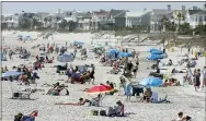  ?? MIC SMITH—ASSOCIATED PRESS ?? Despite warnings from government officials take caution and self distance because of coronaviru­s, beach goers enjoy the Isle of Palms beach, Friday, March 20, 2020, in Isle of Palms, S.C. City authoritie­s are restrictin­g access to the popular beach from 7 a.m. to 7 p.m. daily starting Saturday to help stop the spread of the coronaviru­s.