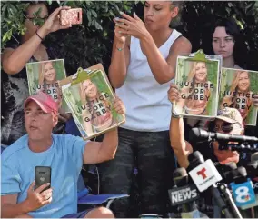  ?? CHRIS O’MEARA/AP ?? Supporters of Gabby Petito hold up photos of her after a news conference Wednesday in North Port, Fla.