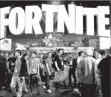  ?? Frederic J. Brown AFP/Getty Images ?? ATTENDEES of the Electronic Entertainm­ent Expo in June crowd a display for “Fortnite,” which is on track to make more than $2 billion this year. Revenue comes from players’ in-game purchases to upgrade avatars.