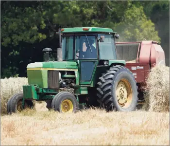  ?? Steve Helber / Associated Press ?? Farmer John Boyd Jr., runs his hay bailer at his farm in Boydton, Va., on May 27.