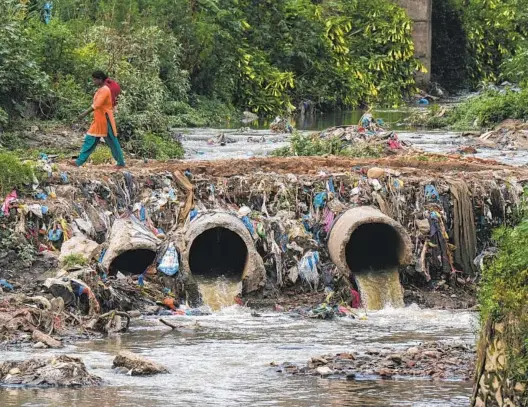 ?? NIRANJAN SHRESTHA AP PHOTOS ?? Drainage pipes flowing into the Bagmati River are surrounded by trash in Kathmandu, Nepal, in June. Disruption­s to trash collection services have led to dumping.