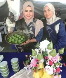  ?? — Bernama photo ?? Noor Farahida shows a tray of tepung suji made by her and Siti Baizura, which earned them second place in the ‘Dessert Preparatio­n’ competitio­n at Karnival Rakyat Pahang.